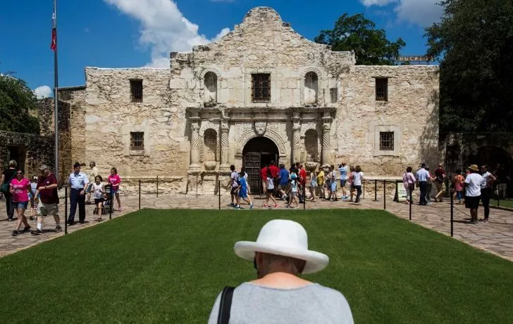 The Alamo Mission building with tourists outside the entrance