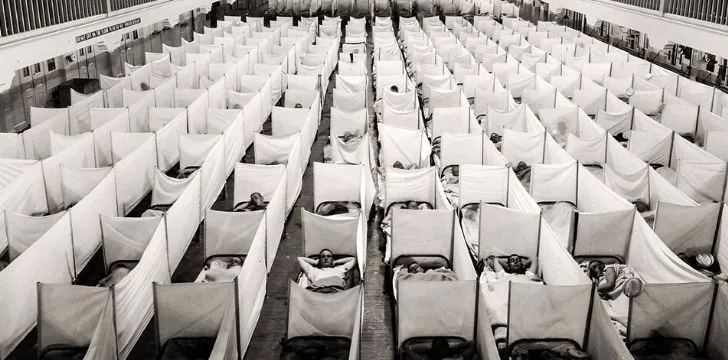 A large hall filled with beds of sick patients