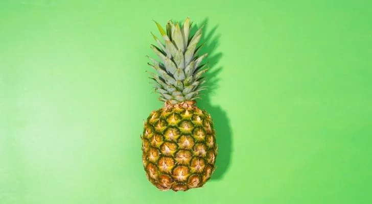 A big juicy pineapple with a green background