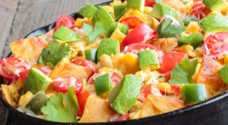 A tex-mex dish with tomato, avocado, and cheese